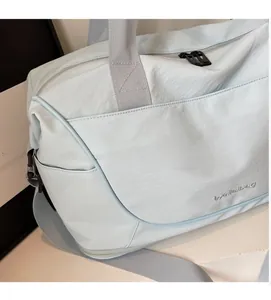 Close-up of light blue travel bag showing water-resistant fabric and Welleilbag logo
