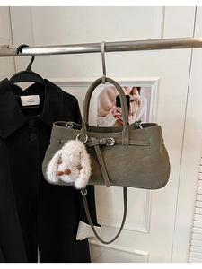 Olive gray handbag detail featuring a cute white bunny pendant and stylish buckle decor