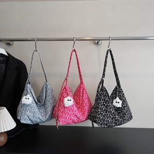 Trois sacs hobo à motifs floraux suspendus avec des breloques pompons blancs décoratifs