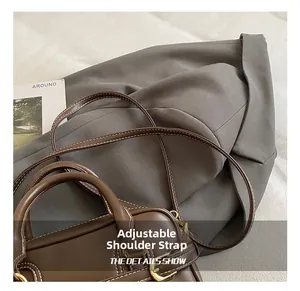 Detail showing the adjustable shoulder strap and gold hardware on a brown leather handbag