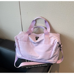 Close-up of lilac waterproof nylon travel bag with woven handles on a leather sofa