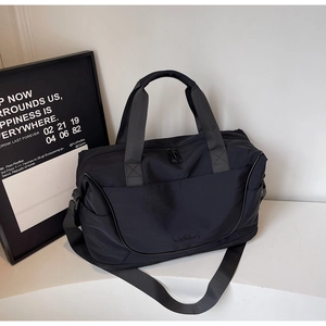 Detail of black large capacity travel bag featuring reinforced handles and shoulder strap