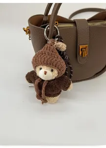 Porte-clés ours en peluche marron tricoté avec cœur rouge sur un sac en cuir