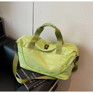 Close-up of avocado green travel bag with durable straps and brand logo on a sofa