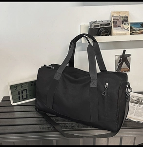 Macro view of a black gym bag showing the durable nylon fabric and reinforced handles