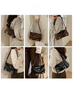 Detail view of vintage baguette bag featuring adjustable strap and buckle decorations