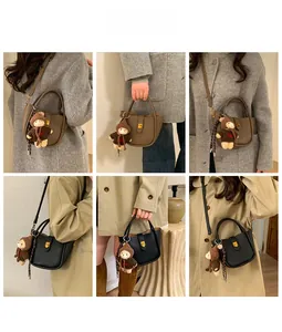 Détail du sac cabas en daim vintage avec fermoir doré et charmant petit ours peluche