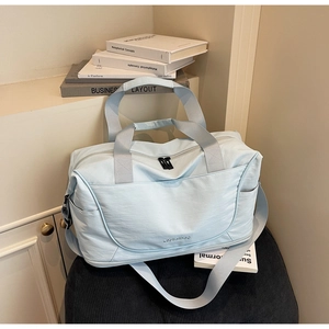 Close-up of baby blue travel bag with water-resistant fabric and Wellallbag logo