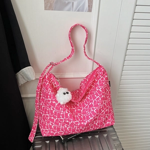 Détail du sac fourre-tout en toile à pois roses avec peluche sur valise argentée