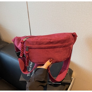 Détail du sac de poitrine en velours côtelé bordeaux avec texture et double fermeture