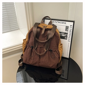 Detail of waterproof nylon backpack showing drawstring pocket and contrast stitching texture