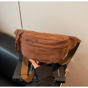 Détail d'un sac à bandoulière en tissu marron texturé avec fermeture éclair en corde tressée