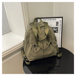 Detail of olive green waterproof nylon backpack with drawstring pockets and texture