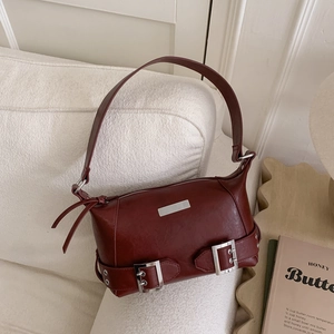 Detail of burgundy faux leather pillow bag with silver buckle and vintage hardware
