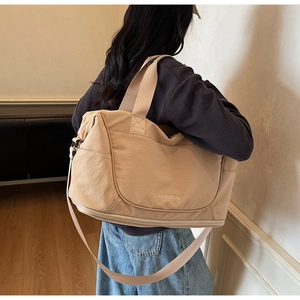 Detail of beige large travel bag showing spacious storage and adjustable shoulder strap