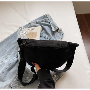 Détail du sac à bandoulière en toile noire minimaliste avec sangle réglable et zip