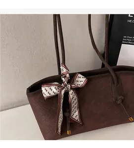 Gros plan sur le sac fourre-tout tissé marron avec embout métallique et foulard décoratif