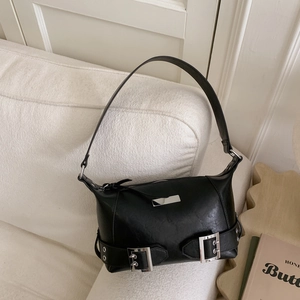 Detail of black leather underarm bag with silver metal buckle on a woven chair