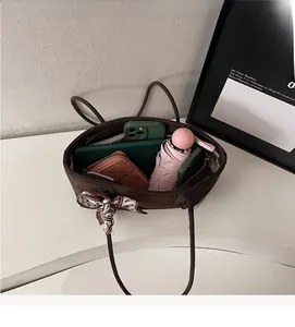 Vue détaillée de l'intérieur spacieux du sac cabas marron café avec des objets du quotidien