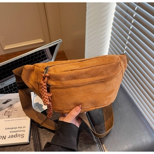 Détail du sac bandoulière en velours côtelé avec double zip et tirettes tressées caramel