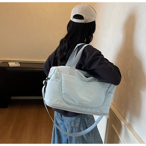 Light blue water-resistant travel bag with shoulder strap and side pocket detail