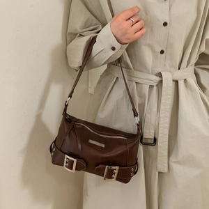 Detail of retro dark brown underarm bag with silver buckles on a trench coat model