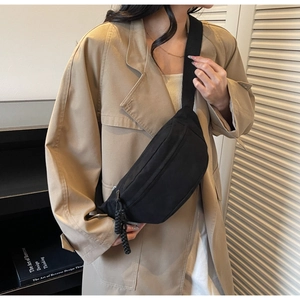 Détail d'un sac de poitrine noir minimaliste en forme de croissant avec bandoulière réglable
