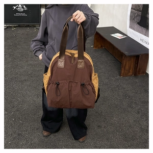 Detail of waterproof nylon backpack featuring dual drawstring pockets and contrast stitching