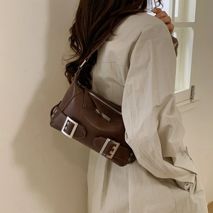 Detail of dark brown retro underarm bag with silver square buckles and smooth zip closure