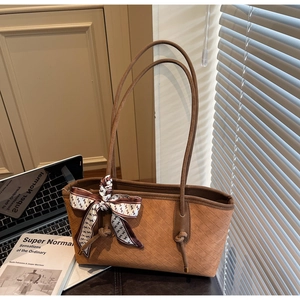 Détail du cabas matelassé marron avec foulard en soie et fine bandoulière élégante
