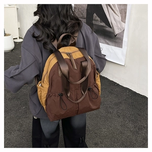 Detailed view of casual nylon backpack in brown and yellow with drawstring side pockets