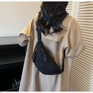 Détail du sac bandoulière en toile noire avec tirettes tissées et grande capacité de stockage