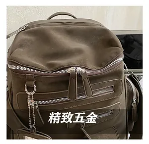 Detail shot of a dark brown leather backpack showing high-quality silver metal hardware