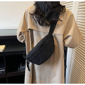 Détail du sac bandoulière noir avec tirette de fermeture tissée et large sangle nylon