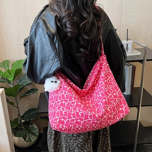 Détail du grand sac cabas en toile à motif abstrait rose avec breloque monstre en peluche
