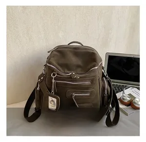 Detail of dark olive canvas backpack with multiple pockets and functional zippers