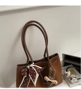 Brown faux leather tote bag with white contrast stitching and a decorative scarf