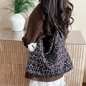 Détail d'un grand sac fourre-tout en toile à motif abstrait noir et blanc et pompon