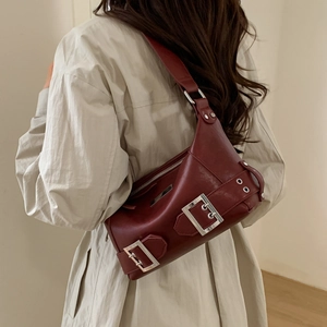 Detail of dark red vintage Y2K shoulder bag with silver buckles and glossy PU texture
