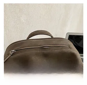 Detail of the reinforced top handle and zipper pocket on a brown vintage tote bag
