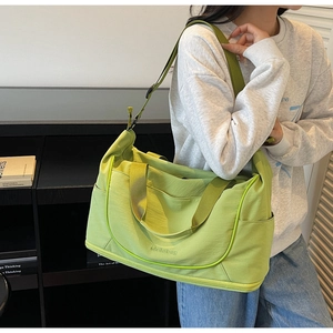 Macro view of the light green travel bag showing waterproof nylon texture and shoe compartment
