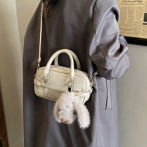 Detail of off-white Boston bag with plush rabbit pendant and long adjustable shoulder strap