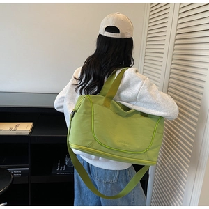 Detail view of large green travel bag with separate bottom shoe compartment and carry straps