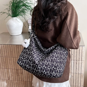 Détail du sac cabas en toile avec motifs d'ours et un pendentif en peluche blanc
