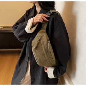 Détail du sac de poitrine vert armée avec tirettes tressées et sangle réglable