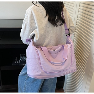 Close-up of lilac travel bag with double handles and adjustable shoulder strap