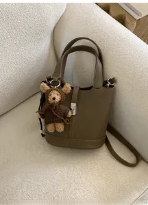 Dettaglio della borsa a secchiello in pelle martellata con ciondolo a forma di orso