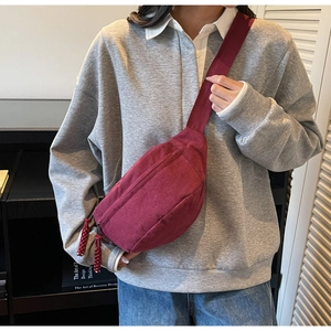 Détail du sac bandoulière en toile bordeaux avec sangle réglable et tirette tissée