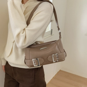 Close-up of brown PU leather shoulder bag with silver buckle and adjustable strap