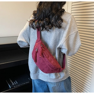 Détail du sac bandoulière en toile bordeaux avec fermeture éclair en corde tressée